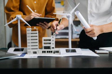 Çalışan iş adamları ve yeşil yenilenebilir enerji arayüzü ve dijital tablet kullanıyorlar. Yenilenebilir kaynaklara dayalı sürdürülebilirlik işi kavramı 