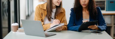 Modern ofiste tablet ve laptop kullanan iki iş adamı. 