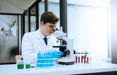 Modern tıbbi araştırma laboratuvarı. Erkek bilim adamı mikro pipetlerle çalışıyor. Biyokimyasal örnekleri analiz ediyor. Gelişmiş tıp kimya laboratuvarı..