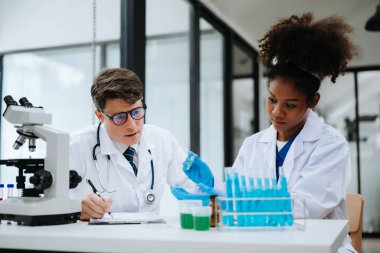 Odaklanmış erkek doktor ve Afrikalı kadın hemşire tablet ve dizüstü bilgisayara bakıyorlar ve birlikte anesteziyi tartışıyorlar. Hastanedeki çeşitli tıp uzmanları...