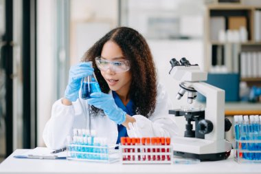 Modern tıbbi araştırma laboratuvarı. Kadın bilim adamı mikro pipetlerle çalışıyor biyokimyasal örnekleri analiz ediyor, tıp için ileri bilim kimya laboratuvarı.