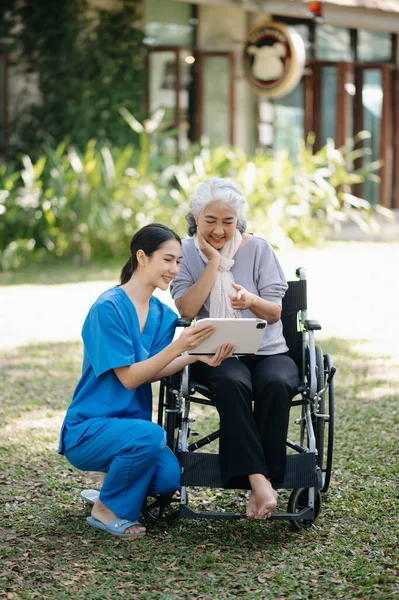 Ηλικιωμένη Ασιάτισσα Ηλικιωμένη Αναπηρική Καρέκλα Ασιάτη Προσεκτική Φροντιστή Και Ενθαρρύνει Royalty Free Εικόνες Αρχείου