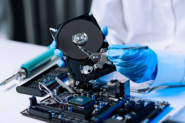  Teknisyenin masasında sabit disk ve bir bilgisayar ana kartı var. atölyedeki veri, donanım ve bilgi teknolojisi kavramı 