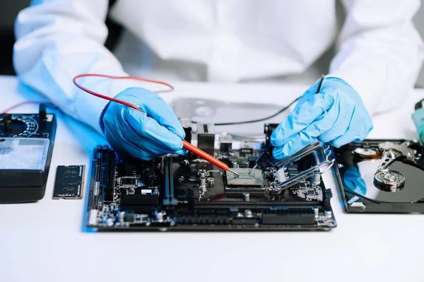 The technician is putting the CPU on the socket of the computer motherboard. electronic engineering electronic repair, electronics measuring and testing, repair in office