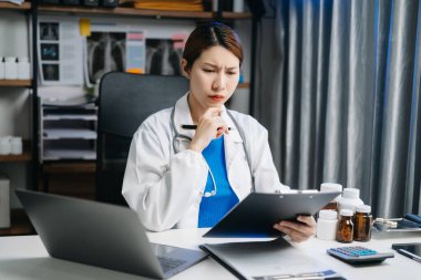 Ofis hastanesindeki masada oturan güzel doktor. İş için dizüstü bilgisayar kullanan çekici bir kadın terapist. 