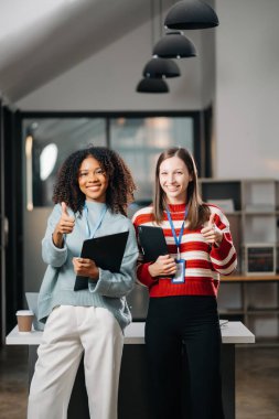 Afrikalı kadın çalışanlar ve meslektaşları ofiste başparmaklarını gösteriyorlar