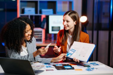  UX geliştiricisi ve ui tasarımcısı modern ofiste müşteri breif ve renk kodu ile mobil uygulama arayüzü kablo tasarımı hakkında beyin fırtınası yapıyorlar