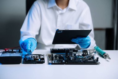  Teknisyenin masasında sabit disk ve bir bilgisayar ana kartı var. atölyedeki veri, donanım ve bilgi teknolojisi kavramı 