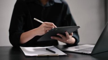 Modern ofiste bilgisayar ve tabletle çalışan iş kadını