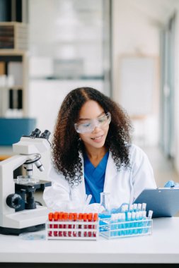 Modern tıbbi araştırma laboratuvarı. Kadın bilim adamı mikro pipetlerle çalışıyor biyokimyasal örnekleri analiz ediyor, tıp için ileri bilim kimya laboratuvarı.