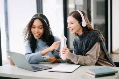 Okul projesinde birlikte çalışan iki çekici genç kız üniversite öğrencisi.