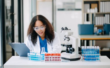 Modern tıbbi araştırma laboratuvarı. Kadın bilim adamı mikro pipetlerle çalışıyor biyokimyasal örnekleri analiz ediyor, tıp için ileri bilim kimya laboratuvarı.