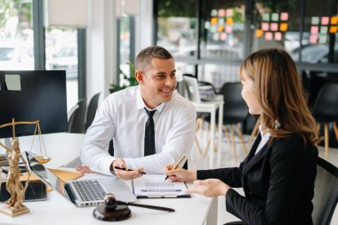İş adamları ya da avukatlar masada oturmuş sözleşme belgelerini tartışıyorlar. Hukuk kavramları, tavsiyeler, hukuk hizmetleri