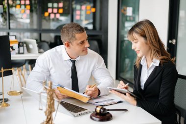 İş adamları ya da avukatlar masada oturmuş sözleşme belgelerini tartışıyorlar. Hukuk kavramları, tavsiyeler, hukuk hizmetleri