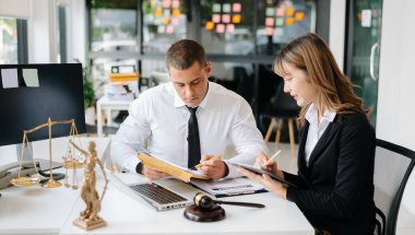 İş adamları ya da avukatlar masada oturmuş sözleşme belgelerini tartışıyorlar. Hukuk kavramları, tavsiyeler, hukuk hizmetleri
