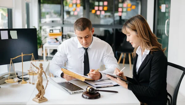 İş adamları ya da avukatlar masada oturmuş sözleşme belgelerini tartışıyorlar. Hukuk kavramları, tavsiyeler, hukuk hizmetleri