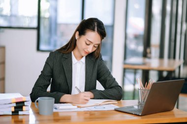 Başarılı Asyalı iş kadını modern ofiste not defterine not alıyor. vergi, rapor, muhasebe, istatistik ve analitik araştırma kavramı