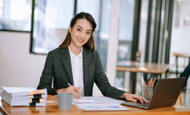 Modern Ofis 'te dizüstü bilgisayarda başarılı bir Asyalı İş kadını Analiz Finansmanı. vergi, rapor, muhasebe, istatistik ve analitik araştırma kavramı