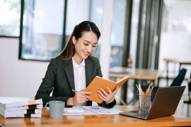 Modern Ofis 'te dizüstü bilgisayarda başarılı bir Asyalı İş kadını Analiz Finansmanı. vergi, rapor, muhasebe, istatistik ve analitik araştırma kavramı