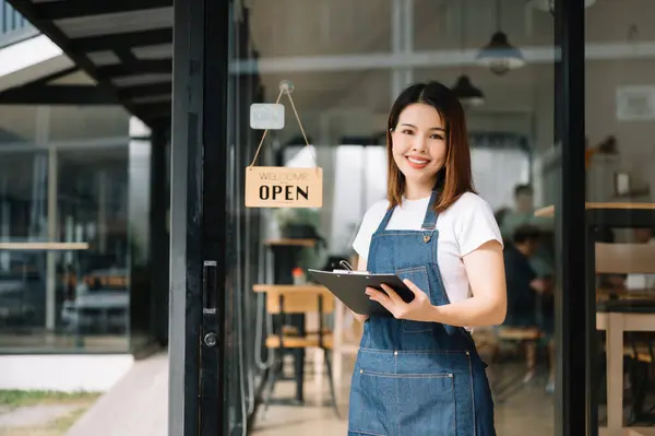Startup successful small business owner sme woman standing at in cafe restaurant with clipboard. woman barista cafe owner.