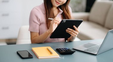 Modern ofisin iş yerinde dijital tablet üzerinde çalışan kendine güvenen bir iş kadını