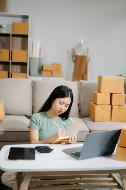 Başlangıçta küçük işletme KOBİ 'si, dizüstü bilgisayar kullanan girişimci sahibi, paket ürün kutusu hazırlamak için çevrimiçi alışveriş siparişi alan ve kontrol eden.