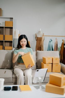 Küçük işletme girişimcisi KOBİ 'de çalışan serbest çalışan kadın, tablet, pazarlama, ambalaj, dağıtım, e-ticaret kavramı kullanıyor