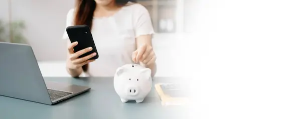 Asian Women are putting coins in a piggy bank for a business that grows for profit and saving money for the future. planning for retirement concept