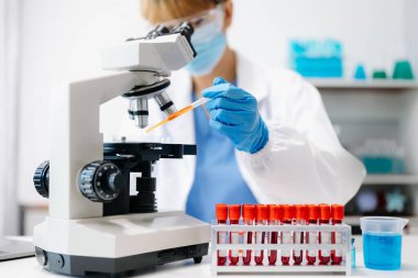  Kadın bilim adamı mikro pipetlerle çalışıyor biyokimyasal örnekleri analiz ediyor, tıp için ileri bilim kimya laboratuvarı.