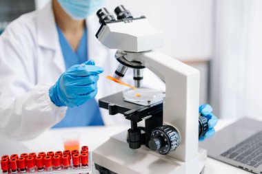  Kadın bilim adamı mikro pipetlerle çalışıyor biyokimyasal örnekleri analiz ediyor, tıp için ileri bilim kimya laboratuvarı.
