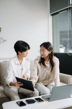 Modern ofiste genç iş adamlarının koltukta birlikte çalışmasının portresi. Çift çalışması başlangıç konsepti