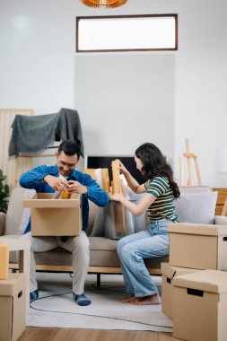 Mutlu Asyalı genç ve çekici çift büyük kutularla yeni bir eve taşınıyor.