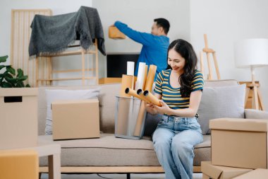 Mutlu Asyalı genç ve çekici çift büyük kutularla yeni bir eve taşınıyor.