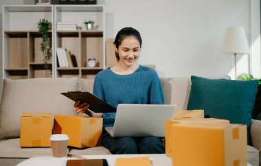 Küçük işletme girişimcisi KOBİ 'li serbest kadın, ev bilgisayarında, pazarlamada, ambalajda, dağıtımda, e-ticaret konseptinde çalışıyor.