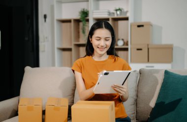 Küçük işletme girişimcisi KOBİ 'li serbest kadın dijital tablet, pazarlama, ambalaj, dağıtım, e-ticaret konsepti üzerinde internet üzerinde çalışıyor