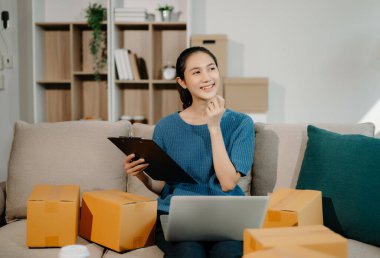 Küçük işletme girişimcisi KOBİ 'li serbest kadın, ev bilgisayarında, pazarlamada, ambalajda, dağıtımda, e-ticaret konseptinde çalışıyor.