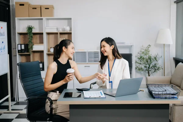 İş kadınları çalışır ve iş planlarını tartışırlar. Bir kadın çalışan, meslektaşına modern ofisteki sonuçları açıklar ve gösterir.
