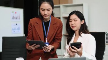 Modern ofiste birlikte çalışan başarılı iş kadınlarının portresi, dizüstü bilgisayar ve dijital tablet kullanarak 