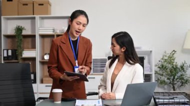 Modern ofiste birlikte çalışan başarılı iş kadınlarının portresi, dizüstü bilgisayar ve dijital tablet kullanarak 
