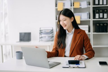 Ofiste çalışmak için dizüstü bilgisayar kullanan kendine güvenen bir iş kadını. 