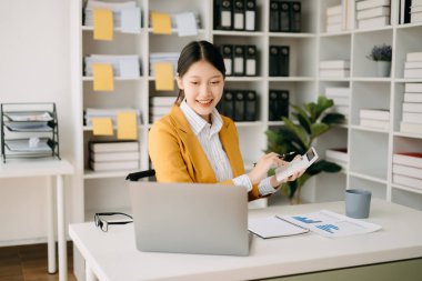 Ofiste çalışmak için dizüstü bilgisayar kullanan kendine güvenen bir iş kadını. 