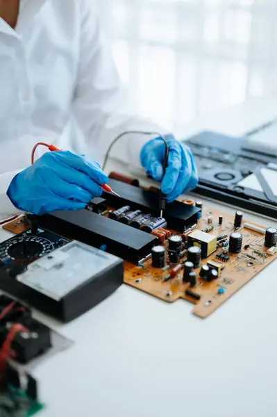 Electronics technician, engineering electronic repair,electronics measuring and testing, repair and maintenance concepts.uses a voltage meter to check and upgrade in workshop