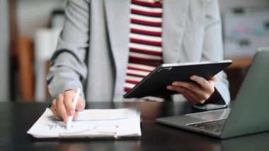 Ofiste dijital tablet kullanan bir iş kadınının orta bölümü 