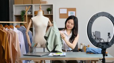 Moda blogcusu konsepti, Asyalı genç bir kadının video yayınında kıyafet satışı. Akıllı telefon ve halka lambasını kullanarak küçük işletme KOBİ 'si başlat 