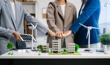 İş adamları toplantı odasında geri dönüşüm sembolüne el koyuyorlar. Yeşil iş şirketi ve Güneş Enerjisi Çevre Kenti Kavramı