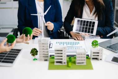 İş adamlarının şirket ofisinde rüzgar enerjisi hakkında görüşleri var. İş ekibi yel değirmenleri ve alternatif yeşil enerji hakkında konuşuyor. Ofiste yönetici toplantısı.