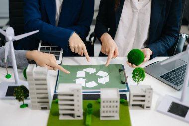 İş adamlarının şirket ofisinde rüzgar enerjisi hakkında görüşleri var. İş ekibi yel değirmeni ve alternatif yeşil enerji hakkında konuşuyor. Modern ofiste yönetici toplantısı. 