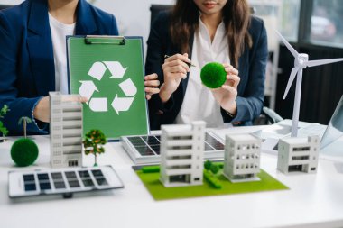 İş adamlarının şirket ofisinde rüzgar enerjisi hakkında görüşleri var. İş ekibi yel değirmeni ve alternatif yeşil enerji hakkında konuşuyor. Modern ofiste yönetici toplantısı.