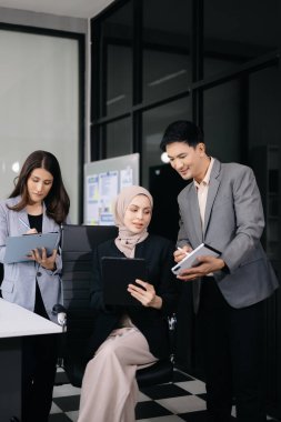İş ortakları toplantıda belge ve fikirleri tartışıyor, yeni başlangıç projesiyle çalışıyorlar.