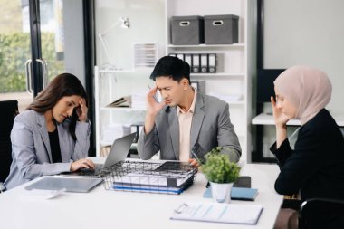 İş ortakları toplantıda belge ve fikirleri tartışıyor, yeni başlangıç projesiyle çalışıyorlar.